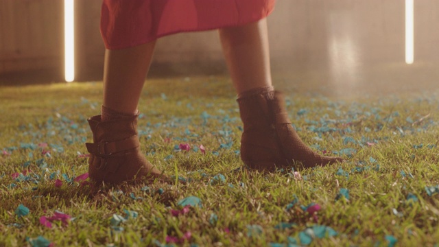 一个女人的靴子在铺满五彩纸屑的草地上跳舞视频下载