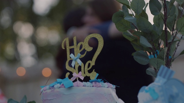 在性别展示派对上的蛋糕上，有一个和她的蛋糕顶部，上面撒着蓝色的纸屑视频下载