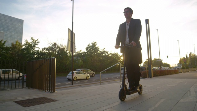 低角度:商人骑着他的电动滑板车在金融区巡游。视频素材