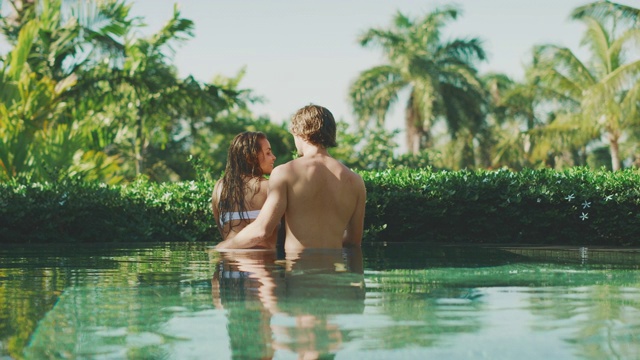 迷人的夫妇享受热带游泳池视频素材