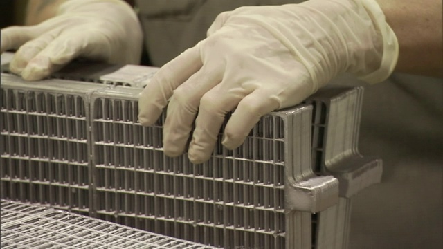 电池工厂的生产工人在分类铅板。视频素材