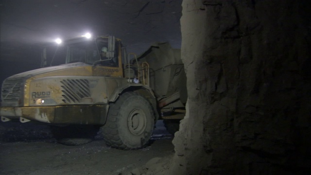 一辆重型采矿拖拉机开过一座铅矿。视频素材