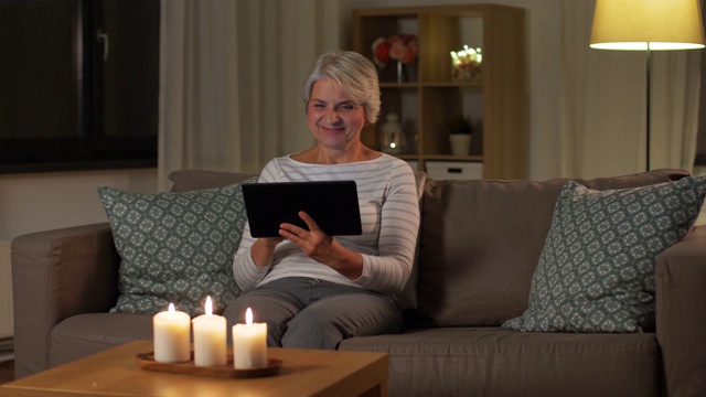 晚上在家用平板电脑的快乐资深女性视频素材