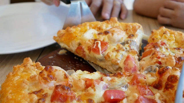 在餐馆里，年轻的亚洲女子用勺子舀着盘子里的披萨吃。视频下载