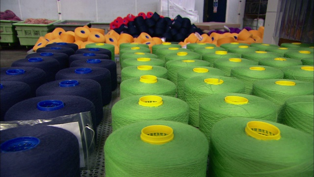 大型彩色线轴填满了一家纺织厂。视频素材