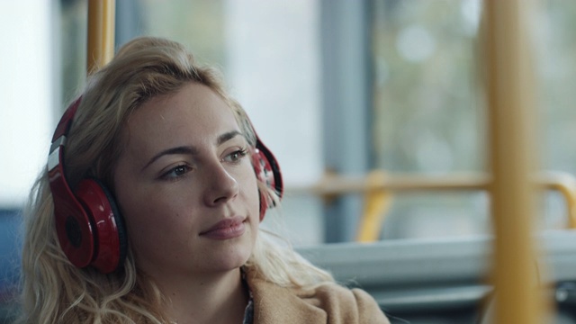在公交车上戴着耳机的女人视频素材