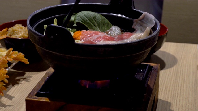 传统的日本火锅在一个餐馆的木桌上视频下载