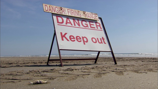 在南威尔士的一个海滩上，一个警告靶场的危险标志。视频下载