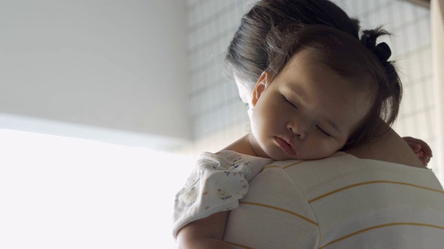 生病的女婴睡在妈妈的肩膀上视频下载