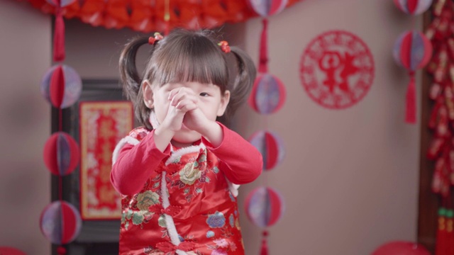 蹒跚学步的小女孩穿着传统服装庆祝中国新年视频购买