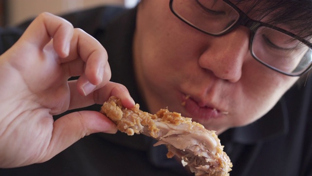 饥饿的亚洲人在快餐店吃炸鸡视频下载