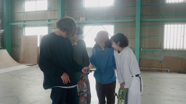 日本的滑板爱好者正在用智能手机查看视频视频素材