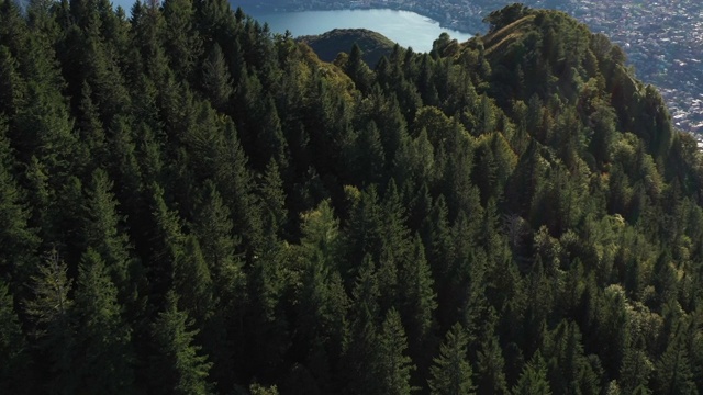 无人机俯瞰日落时的卢加诺湖，森林和山脊视频素材