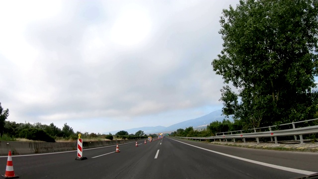 驾驶POV在高速公路上与道路施工标志和塑料塔视频素材