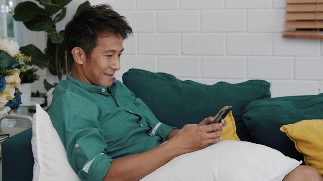 男人在家用智能手机看视频和使用社交网络视频素材