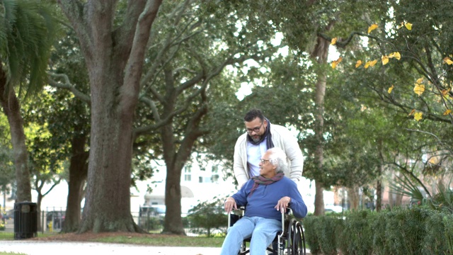 坐轮椅的西班牙裔老人，还有成年的儿子视频素材