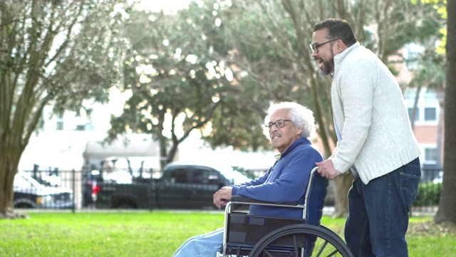 西班牙裔男子推着轮椅上的老父亲视频素材