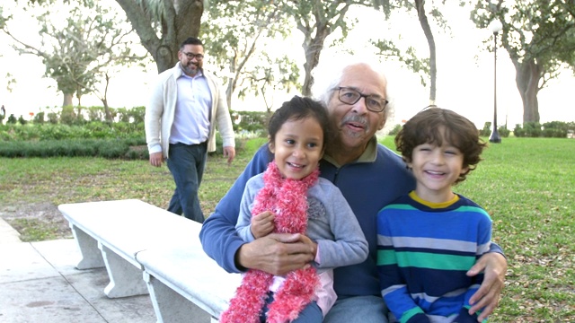 三代拉美裔家庭聚在公园长椅上视频素材