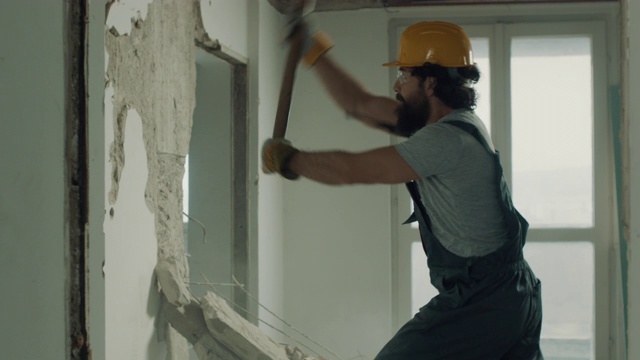 建筑工人正在用大锤拆除墙壁视频素材