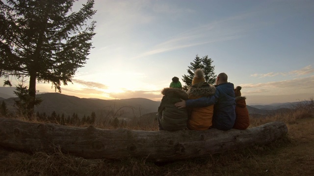 父亲和孩子们在山上欣赏日落视频素材