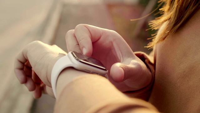 一名女性正在使用她的智能手表触摸屏可穿戴技术设备。视频素材