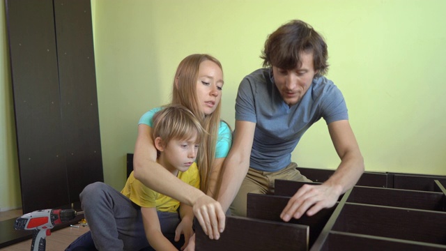 年轻的家庭用架子组装了一个橱柜视频素材