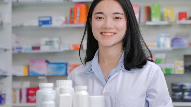 肖像自信亚洲年轻女性药剂师微笑着相机在药店。领导能力，女性在stem，医疗保健和医学，药学，科学，志愿者，非白人药剂师视频下载