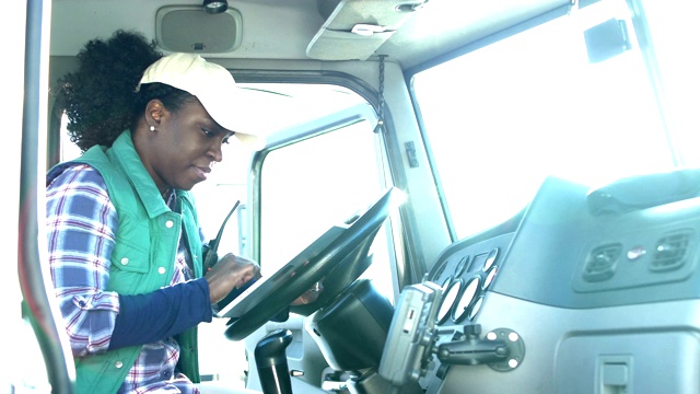 手持数字平板电脑的非裔美国女卡车司机视频下载