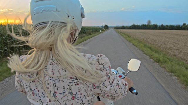 日落时分，一名女子在乡间骑摩托车视频素材