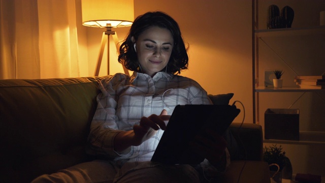 年轻女子在家里使用平板电脑。视频素材
