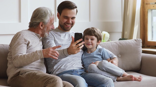 快乐多年龄几代男人家庭使用智能手机笑视频素材