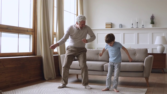 快乐的两代人活跃的家庭舞蹈在客厅视频素材