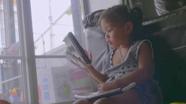 亚洲小女孩使用智能手机在家里库存视频视频素材