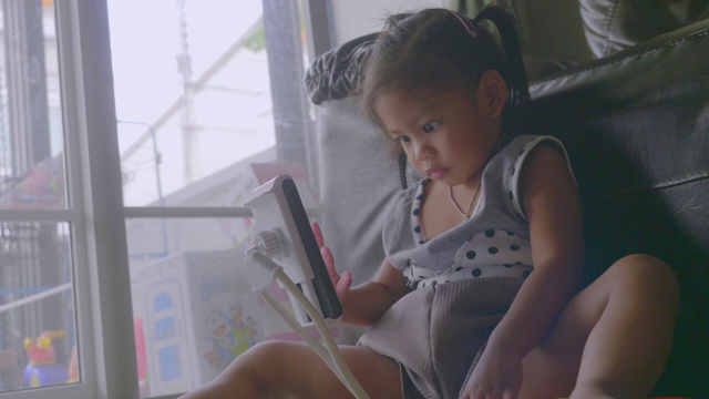 亚洲小女孩使用智能手机在家里库存视频视频素材
