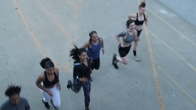 女人们一起在大楼停车场跑步视频素材