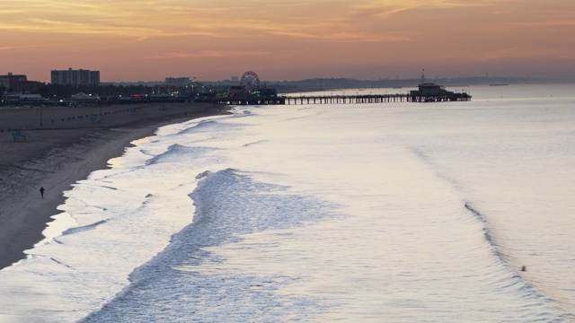 海浪拍击圣塔莫尼卡海滩在日出-无人机拍摄视频素材