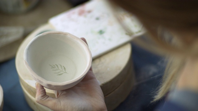 年轻女子在她的陶器作坊里手工制作陶器，这是一种小型的商业理念视频下载