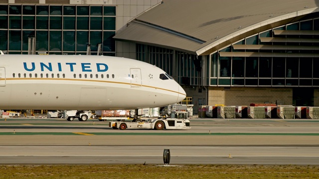 美国联合航空公司的波音787梦想客机被拖车拖着穿过洛杉矶国际机场布拉德利航站楼附近的停机坪视频素材
