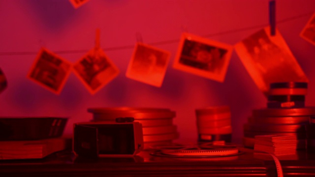 在私人照相馆的红色暗室里，老照片挂在绳上。黑白照片，最爱的爱好，童年记忆的更新记录。开发过程的照片视频下载