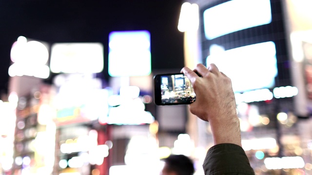 一名游客用智能手机拍摄涉谷Scramble十字路口视频素材