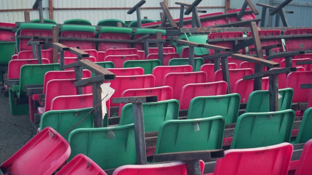 与体育场不同颜色的垃圾填埋场座位。体育场倾销的椅子。视频素材