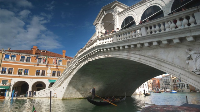 贡多拉从里亚托桥下面经过。这座桥是意大利威尼斯的著名国际地标视频素材