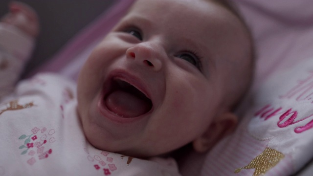 一个小婴儿微笑和大笑的特写视频视频下载