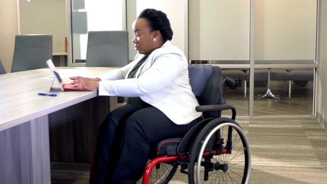 患有脊柱裂的女性在办公室使用平板电脑视频下载