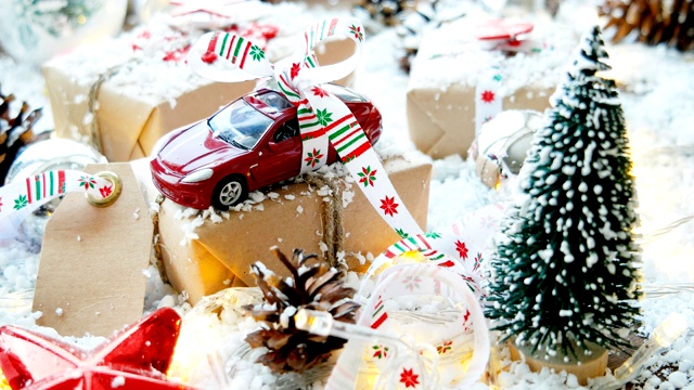 圣诞和新年背景与玩具车礼物用丝带。球，松果和不同的装饰在雪地上。视频下载
