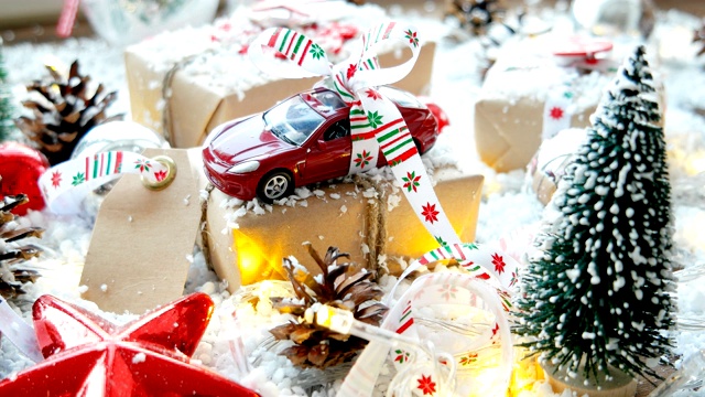 圣诞和新年背景与玩具车礼物用丝带。球，松果和不同的装饰在雪地上。视频下载