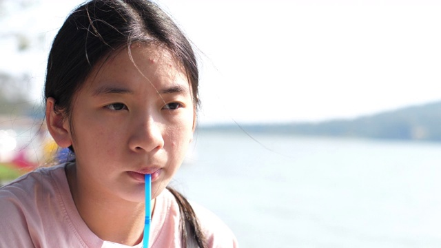 亚洲少女喝果汁，4K视频素材