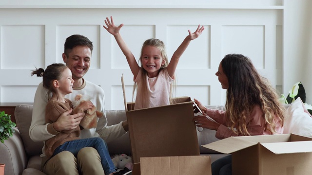 快乐的父母和孩子们在搬家日打开箱子视频素材