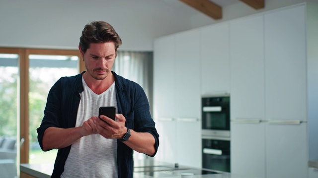 英俊男子使用手机由厨房岛视频下载