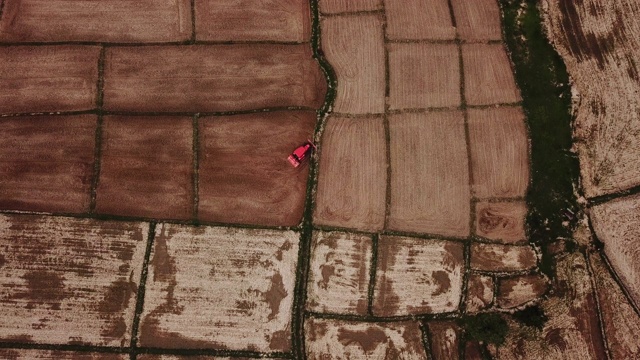 农业拖拉机犁田农业稻田梯田小麦田在夏季旱季，鸟瞰图视频下载
